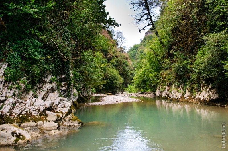 Путь к каньону лежит вдоль реки с каменистыми берегами.